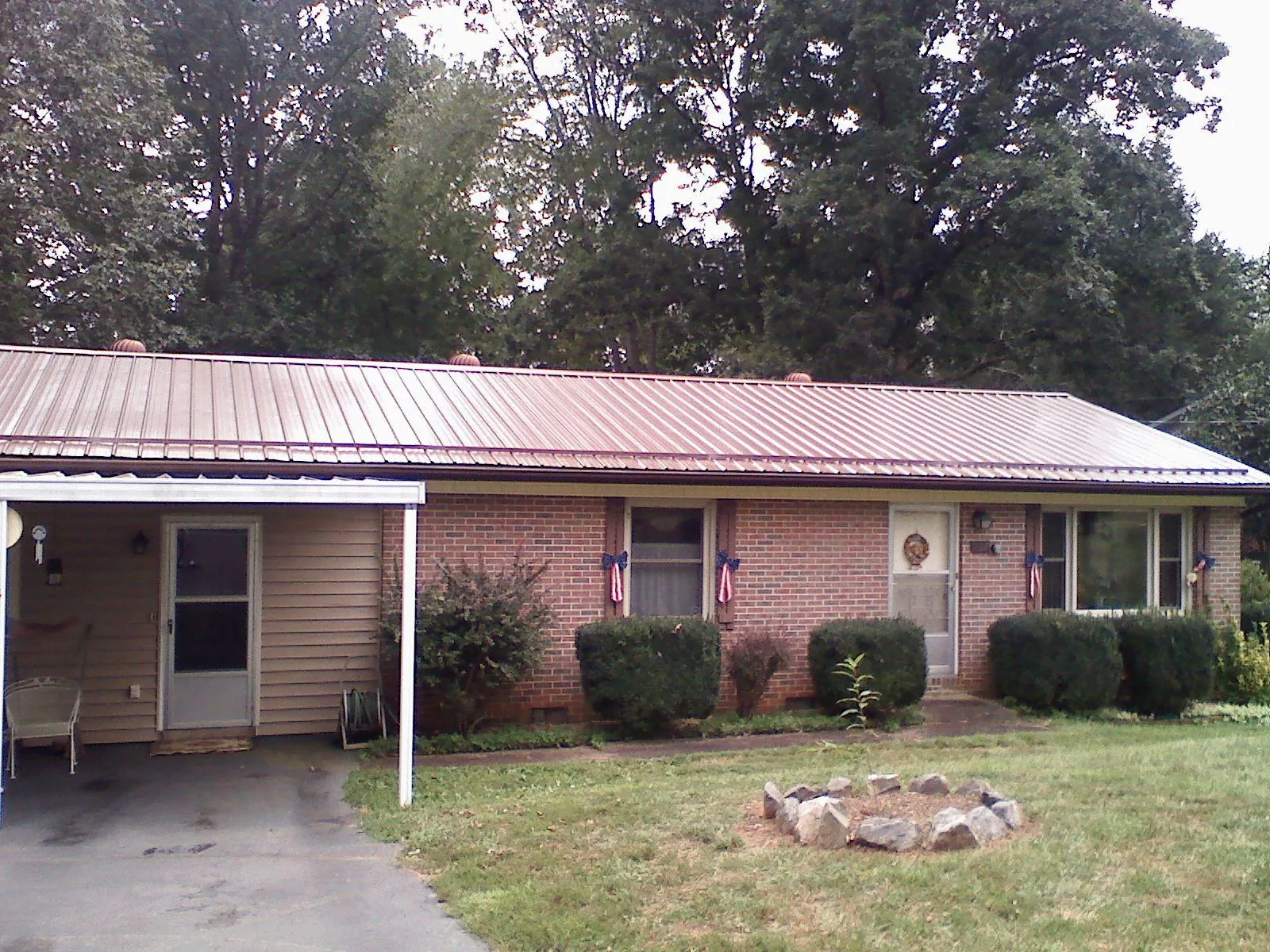 Bronze metal roof and carport on a brick ranch home — Roof Repair work by our crew in Lone Oak